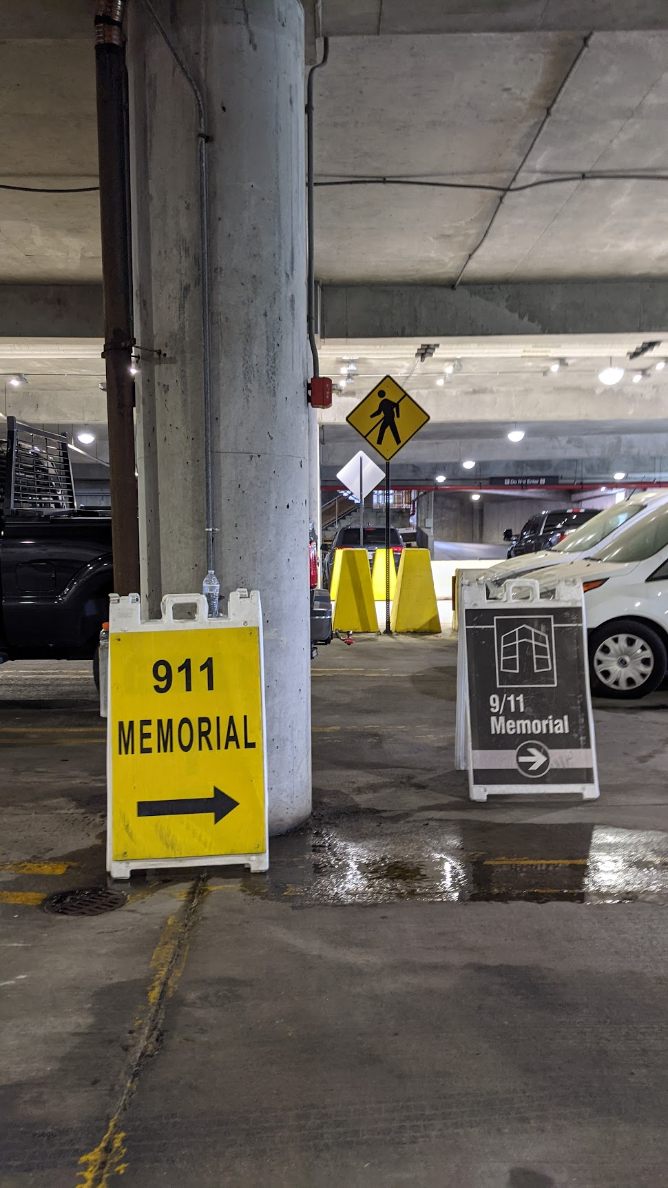 Two signs in a parking garage for the 9/11 Memorial at Boston Logan Airport